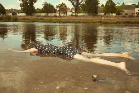 穿黑色衣服的妇女在城市夏河岸附近被淹死照片