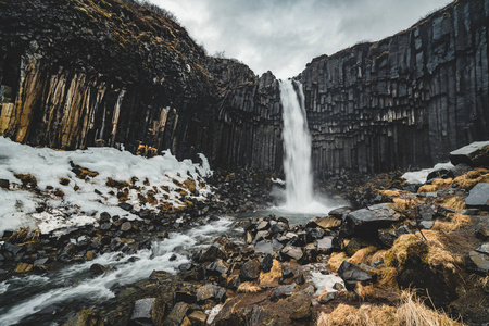 戏剧性的清晨景色著名的 Svartifoss 瀑布。五彩缤纷的夏日日出在 Skaftafell, Vatnajokull 国家公