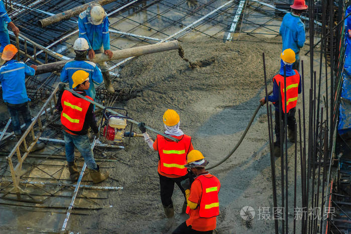 梅森工人从混凝土泵或也称为大象软管在混凝土工作在施工现场
