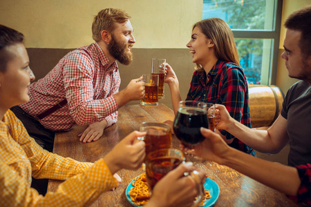 人 休闲 友谊和沟通的概念   快乐的朋友喝啤酒，说话和无比眼镜在酒吧或酒馆