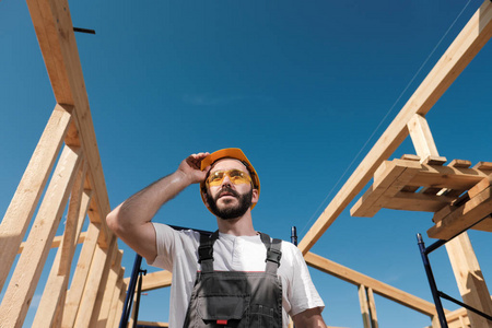 这个人是一个木框架房子屋顶上的建筑工人