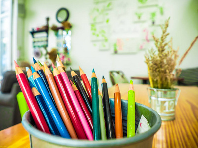 五颜六色的铅笔被组合在室桌子上的一个钢制盒子里。