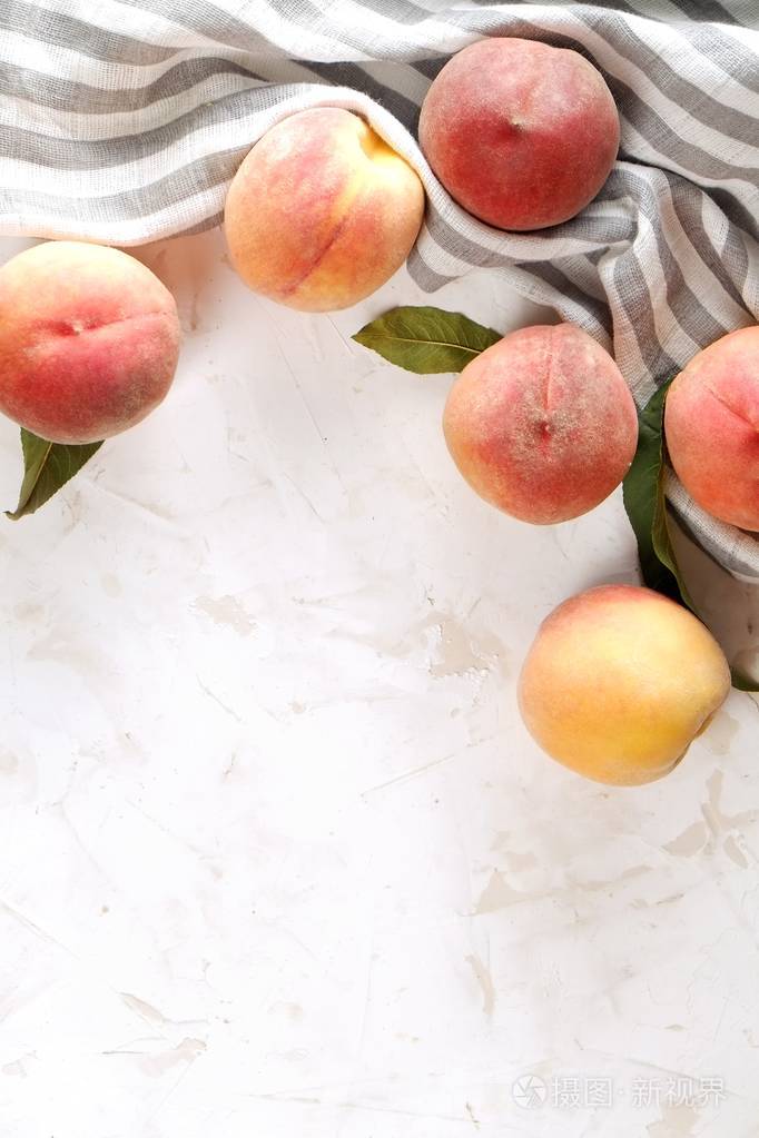 一堆成熟的有机桃子在白色混凝土表面的桌子上. 当地生产收获堆在老式