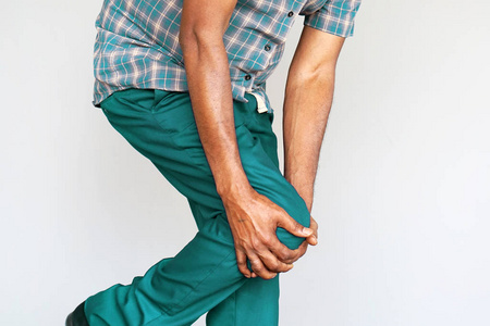 男人感觉关节疼痛,有健康问题和触摸腿与手.身体和保健概念.照片