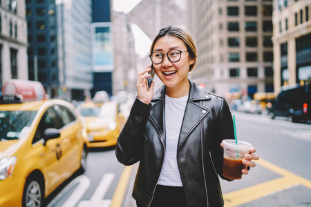 徜徉在大城市的大街上，带着咖啡去亚洲女孩打电话叫出租车，在市中心漫步的移动服务运营商