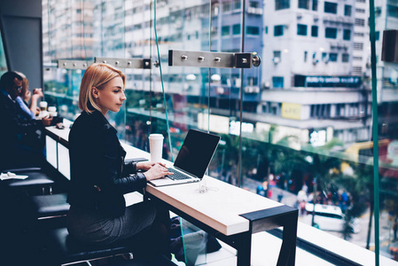 专接本时尚的金发年轻女性工作自由职业者,使用4g互联网连接到上网本