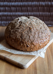 新烤的自制面包在木板上。 桌子上的砧板上的乡村圆面包。 乡村风格。 还活着
