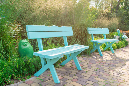 阳光明媚的夏日自由空间，城市公园孤独的装饰绿松石木凳