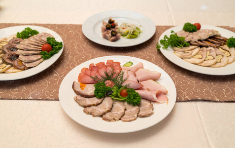 冷肉盘与美味的火腿片，火腿，肉和蔬菜，在庆祝餐桌上选择性集中。 精选肉盘