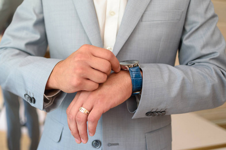 穿西装的新郎准备结婚. 新郎手持手表照片