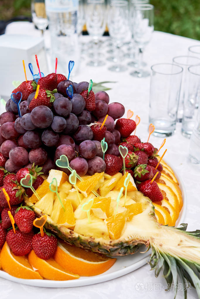 盘子与切片水果和浆果在美味的自助餐桌上在豪华的婚宴户外复制空间