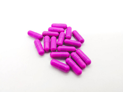药物和保健概念。 在白色背景上分离出许多克林霉素300毫克的紫色胶囊，用于治疗由细菌引起的严重感染。 选择性聚焦和复制空间。