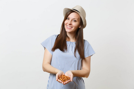 年轻微笑的女人的肖像握在手中，棕色未加工的杏仁坚果分离在白色背景上。 适当的营养，素食，素食，健康的生活方式，节食的概念。 复制