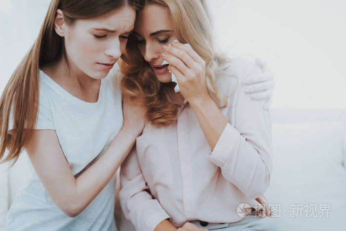 女人在家安慰不幸的十几岁的女儿. 坐在家里的沙发上. 有问题的女孩.