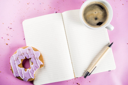 休息和放松概念咖啡杯和饼干甜甜圈与糖涂层与记事本的笔记或愿望，在明亮的时尚背景顶部视图空间的文本。