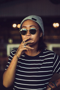 烟灰色发型印尼女孩戴着灰色帽子和太阳镜.