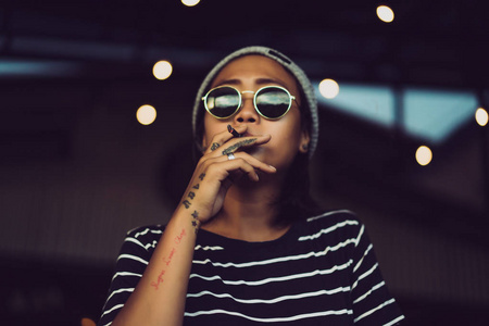 纹身的漂亮时尚的亚洲女人抽烟.照片