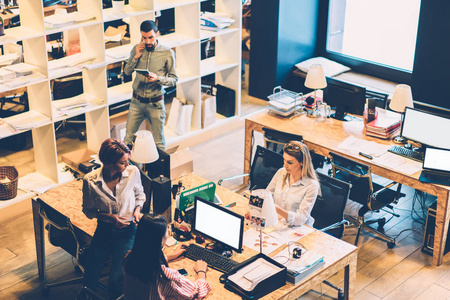 年轻男女员工在时尚办公室内部工作的俯视图.