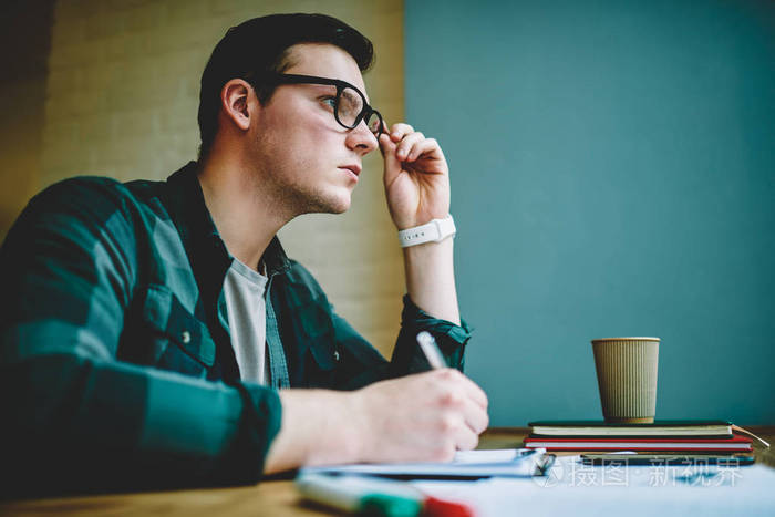 思考问题解决方案,在同事空间做作业,目光呆滞的男学生,专注于创造性