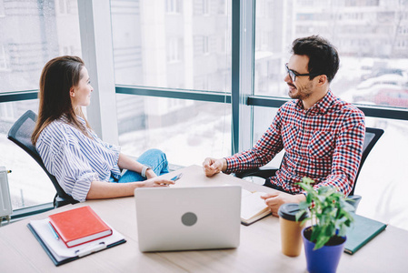 积极的男性和女性同事在办公室进行沟通和合作,微笑的员工互相交谈,对