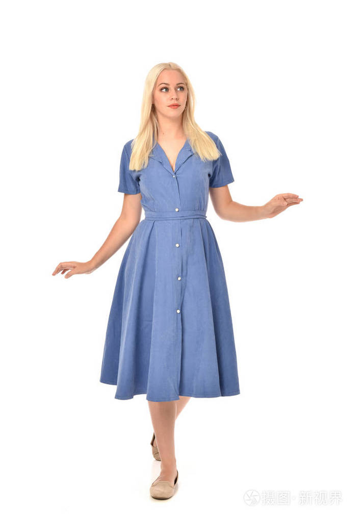 穿蓝色连衣裙的金发女孩的全长肖像. 站姿. 孤立在白色工作室背景上.