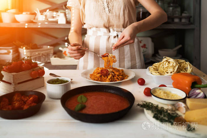 木板新鲜蔬菜煮熟的意大利面和一锅酱汁放在木制厨房