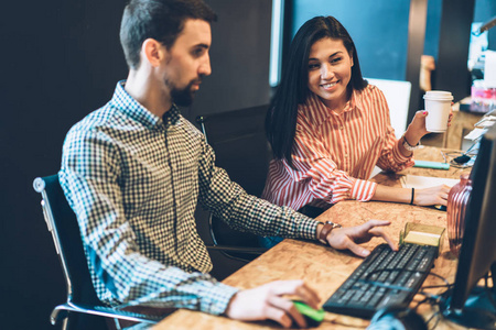 严肃的男性it开发人员在电脑上向年轻的女性学员展示新的应用程序