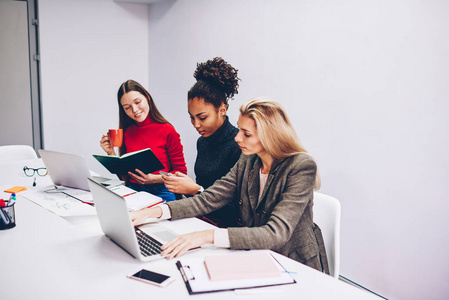 年轻女性在办公室里花时间集中精力完成她们的任务,而忽视了与对方的