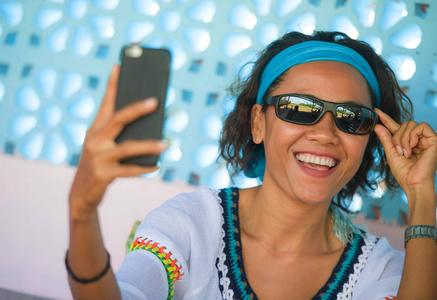 年轻,快乐,迷人的东南亚印尼女孩在假期旅行中,在美丽的背景下,用手机