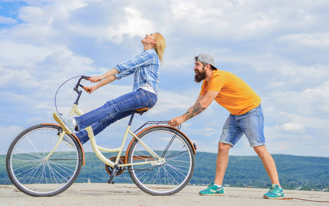 如何学会骑自行车作为成人.女孩骑自行车, 而男朋友支持她.