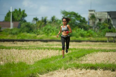 健康的生活方式肖像，年轻，快乐，健康，亚洲，中国跑步妇女在户外运动，绿色领域背景，身体锻炼，保健和健身理念