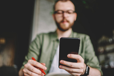 s hand holding modern black smartphone and searching information