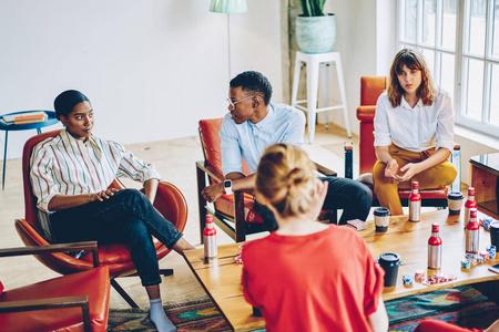 空闲时间和朋友多文化的朋友穿着休闲装,互相交流,用薯片和饮料在扑克