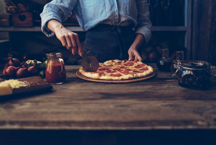 s hands making homemade pizza on the table. Pizza with ingredien