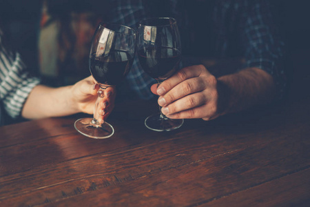 男人和女人在雷托兰喝一杯红酒.酒杯中的酒,选择性聚焦,运动模糊.
