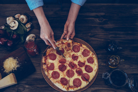 s hands making homemade pizza on the table. Pizza with ingredien