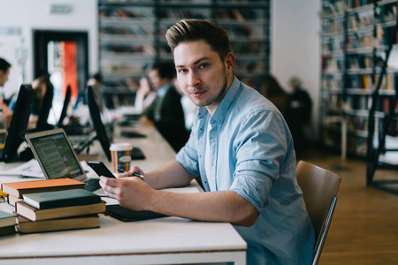 动漫社会图教程书中写道,男性it开发者坐在桌面上与现代科技合作,时髦