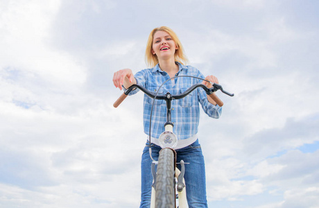 自行车的最高心理效益。女人喜欢骑自行车。每天骑自行车能让你更快乐。女孩放松坐自行车天空背景。骑自行车她的爱好和最好的方式来放松和
