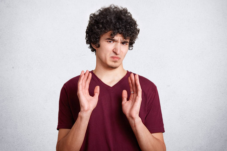 卷曲英俊的青少年有不满意的表情,穿休闲服装.照片