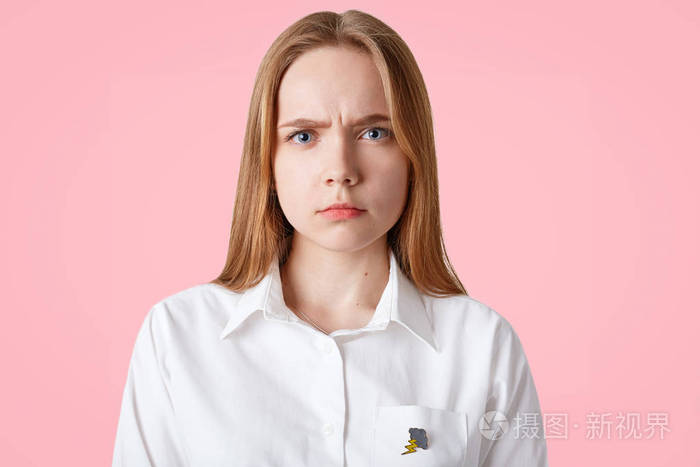 美丽可爱的年轻女性的肖像忧郁的表情皱眉的脸长发健康的皮肤蓝色的