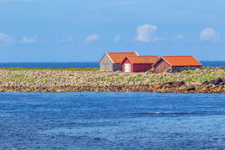 在挪威南岸的Kvasshe im灯塔附近的海滩上孤独的棚屋。 选择性地关注棚子。 地平线被上升的热气模糊了。