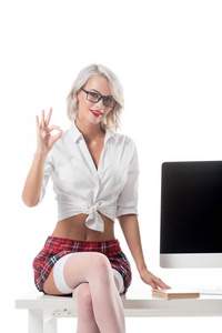 穿着格子短裙的金发诱人女学生，坐在桌子上，白色电脑屏幕被隔离