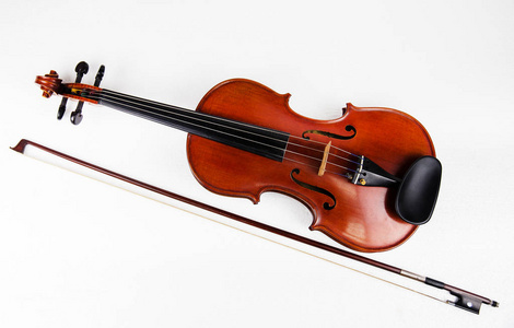 特写经典小提琴放置在木制弓旁边的白色背景显示大小和身体的小提琴.
