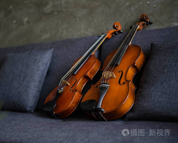 木制小提琴和中提琴放在沙发上