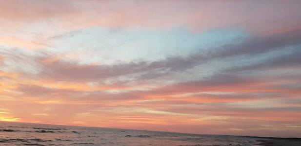 美丽的红色和蓝色的天空与云在波罗的海海滩日落。
