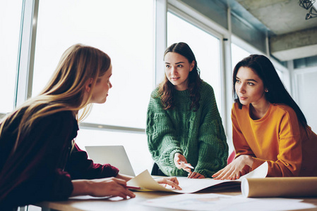 认真的白种人女建筑师小组讨论战略和解决方案,一起检查草图,起草聪明
