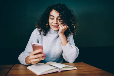 微笑千禧年女青少年在校园规划组织过程中安装应用程序成功的女性搜索博客信息，用手机填充内容