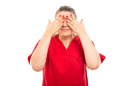 年轻的医疗护士的肖像，穿着红色的擦洗，遮住眼睛，手势被隔离在白色背景上，带有复印空间广告区域