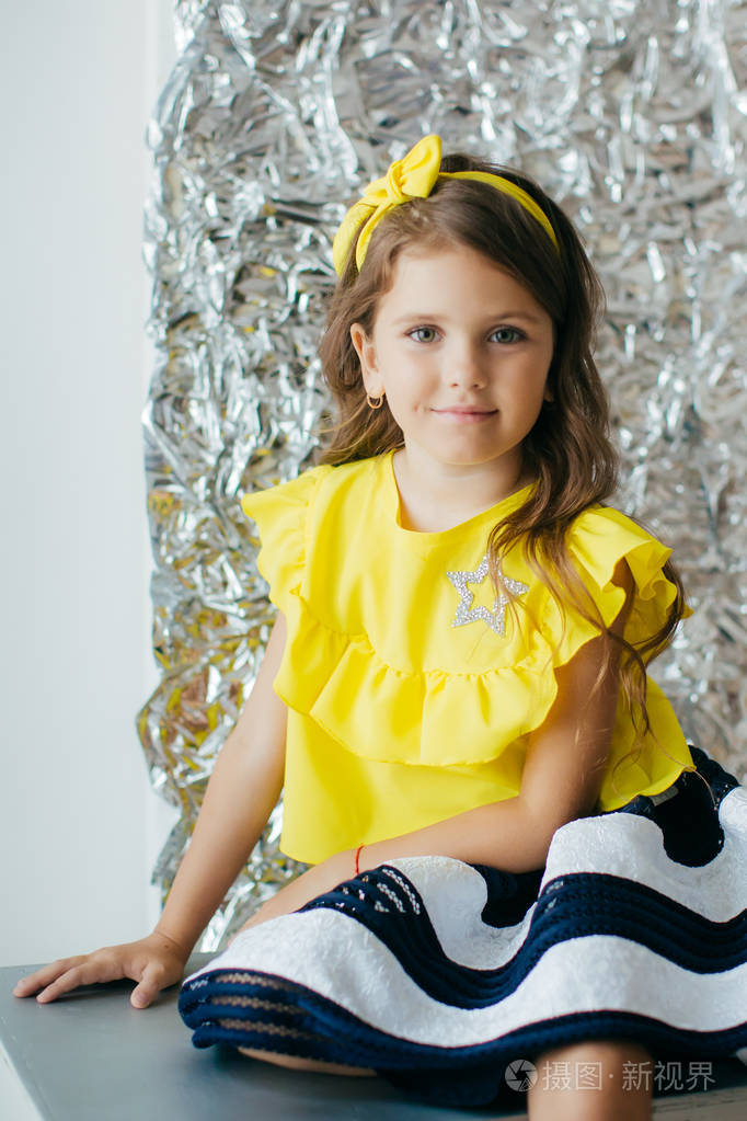 可爱的小女孩在时尚服装摆姿势快乐的童年概念