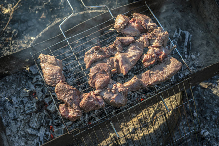 烤肉时煮熟的烤肉。 烧烤新鲜牛肉肉切片。